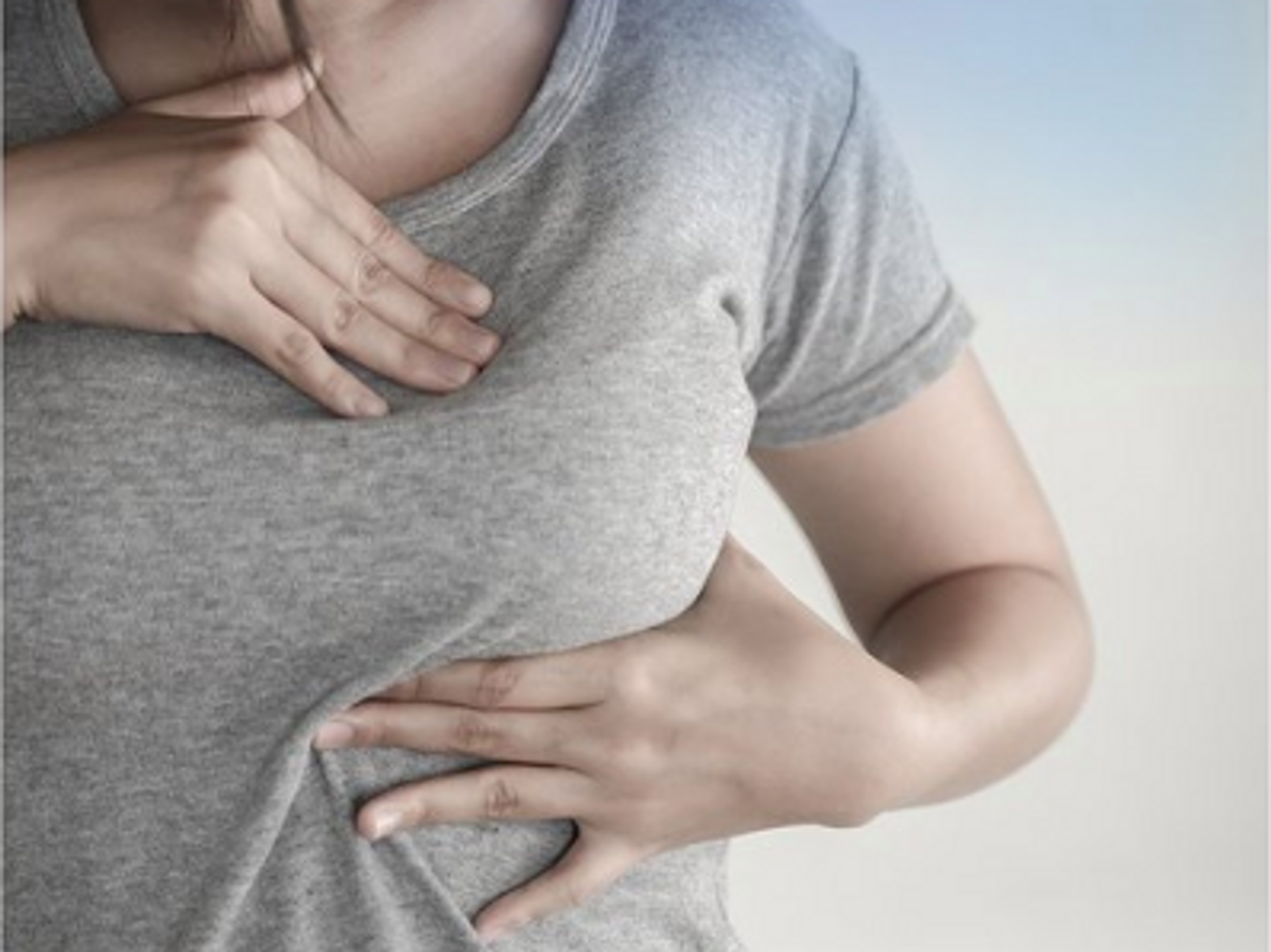 photo of woman checking for lumps in her breast
