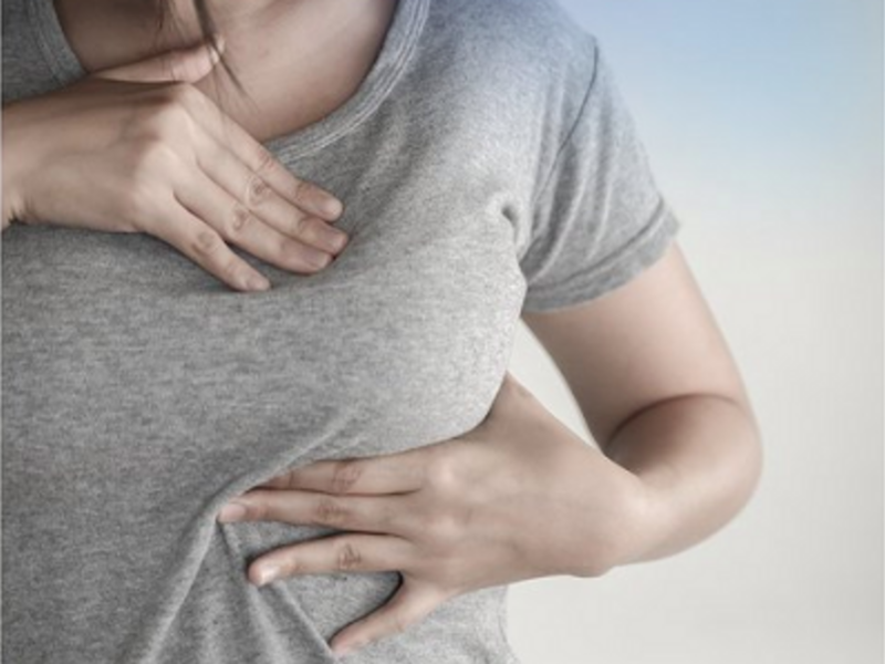 photo of woman checking for lumps in her breast
