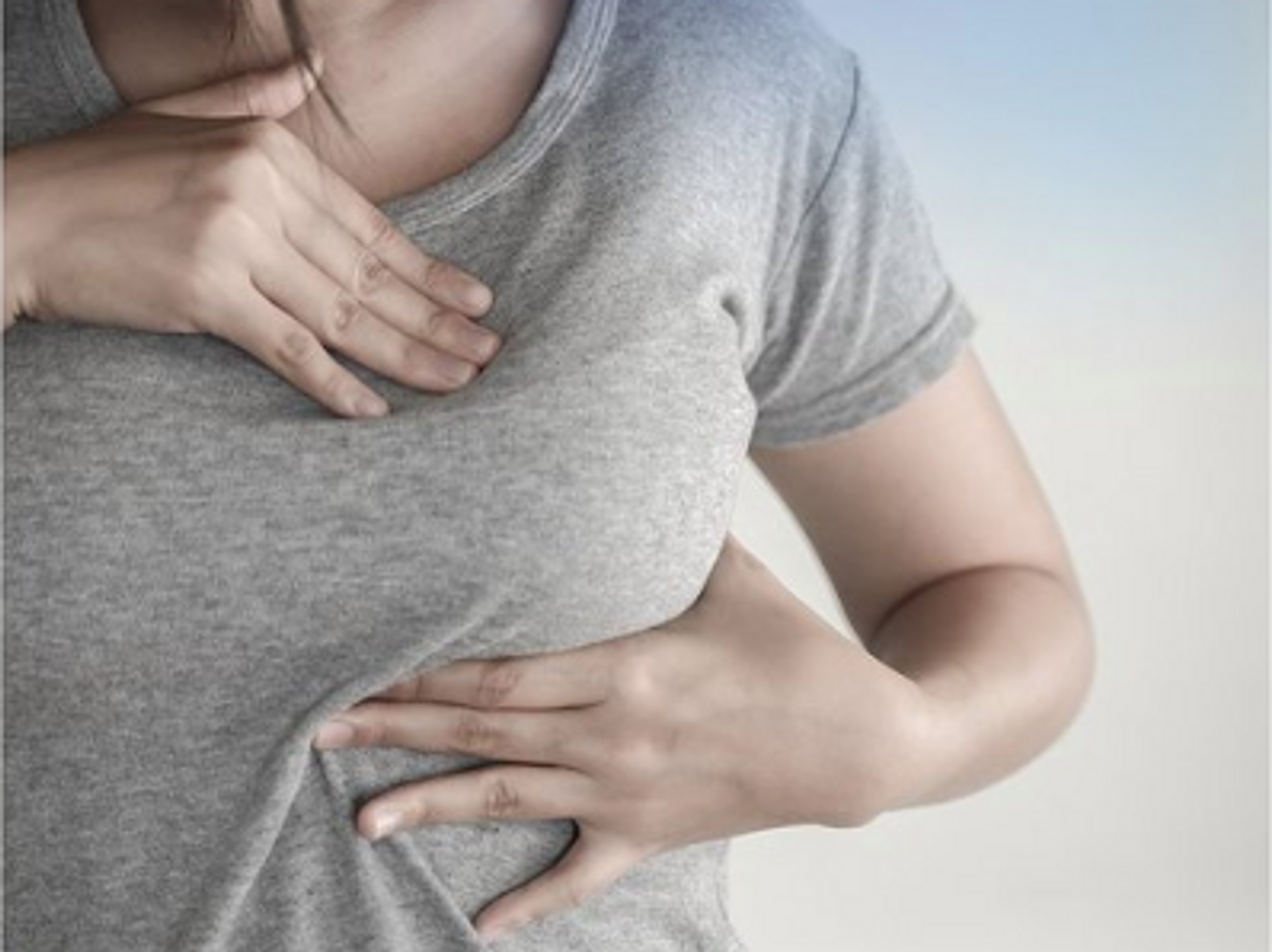 photo of woman checking for lumps in her breast