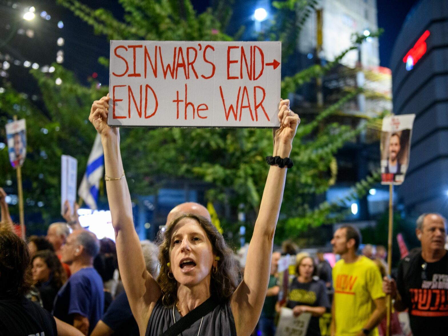 photo of woman holding up poster to end war in gaza
