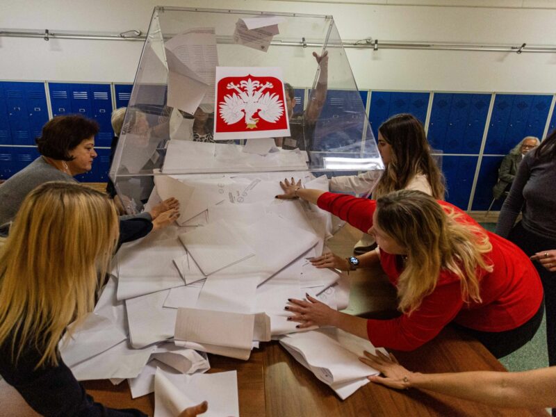 Photo of women emptying a ball box at a polling station after Poland's Oct. 15 election