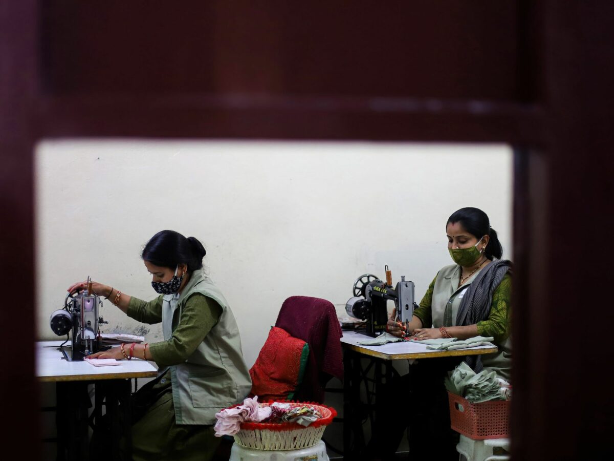 Photo of women in India making cotton cloth reusable sanitary pads