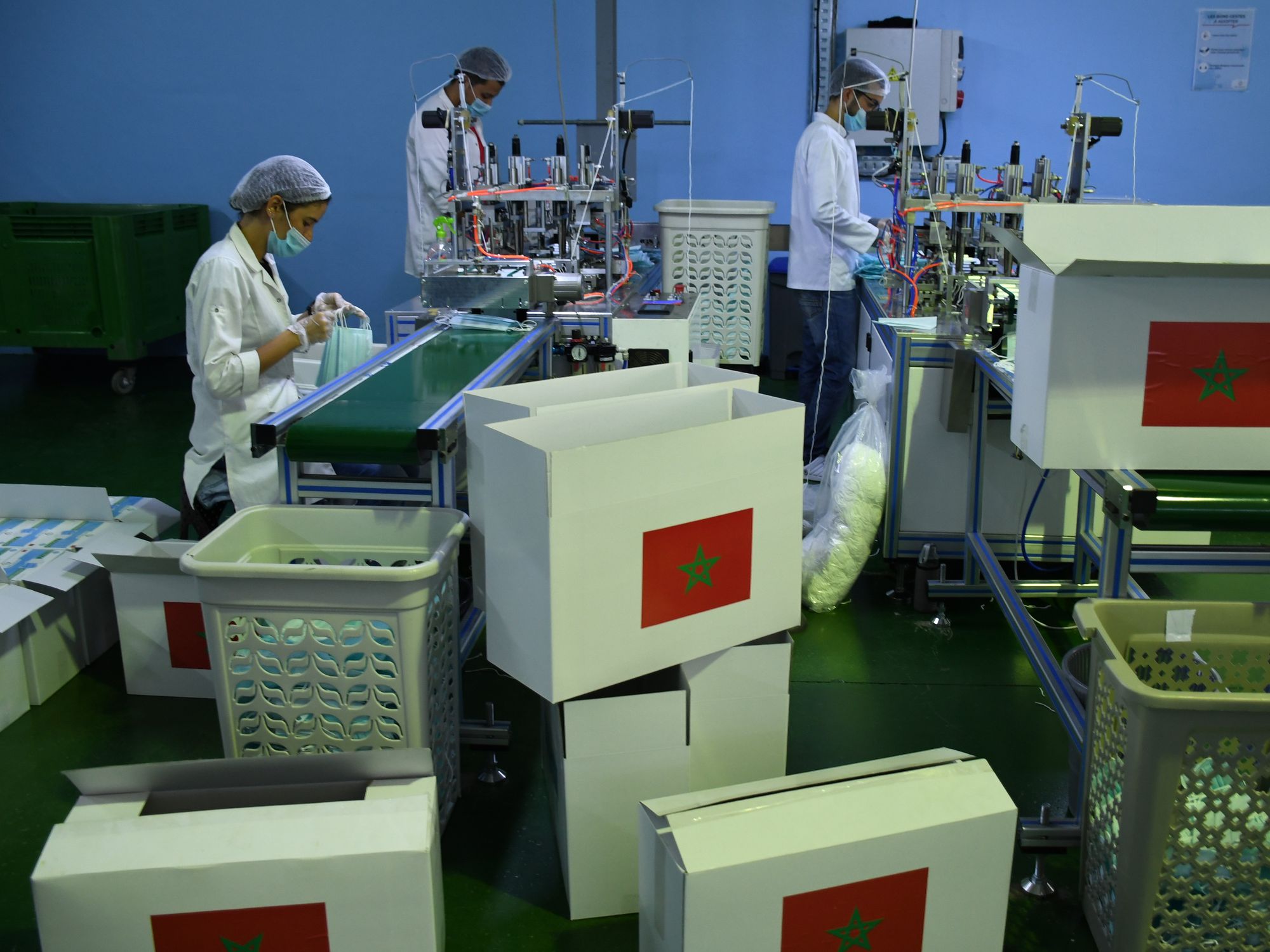 Photo of workers at a factory in Sale, Morocco. In the foreground, boxes with the Moroccan flag on them.