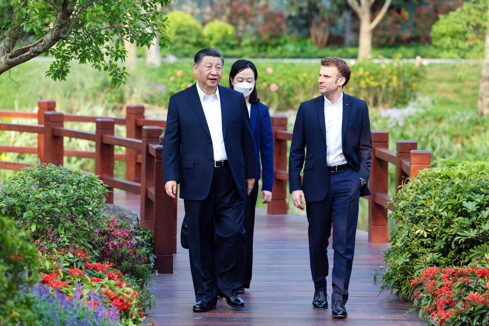 photo of xi and macron walking with a woman interpreter behind them