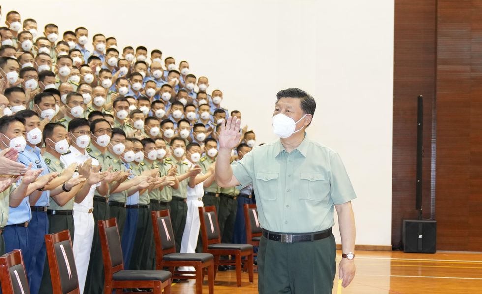 Photo of Xi Jinping waving to audience, all with white masks
