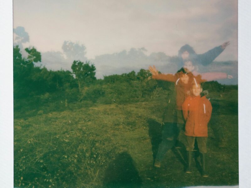 Photo of young boys standing in a field wearing matching jackets.
