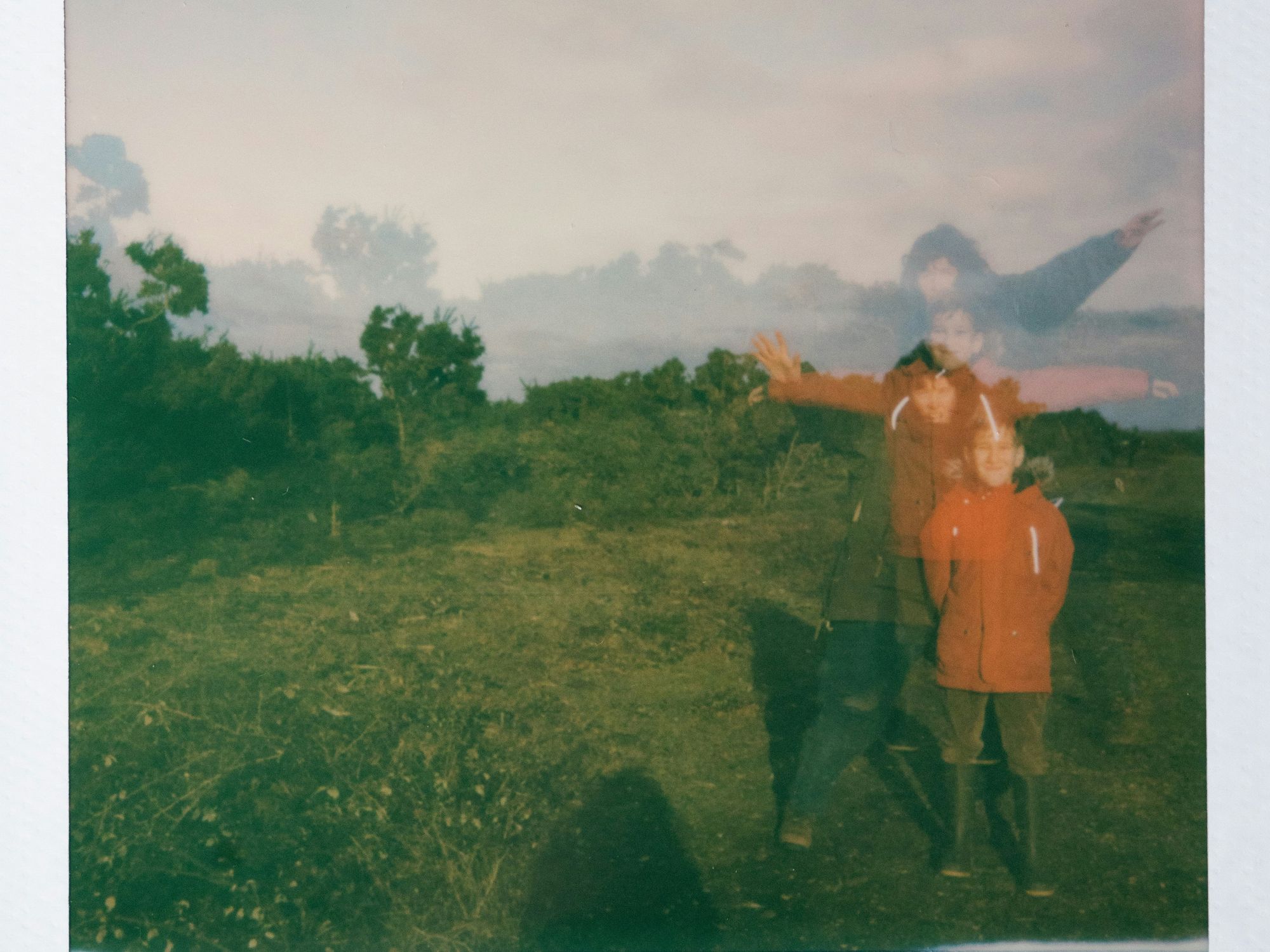 Photo of young boys standing in a field wearing matching jackets.