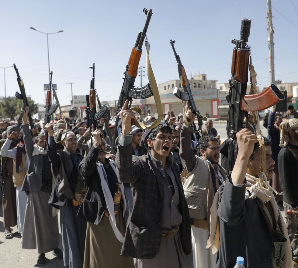 Photo of young Houthi fighters brandishing rifles and chanting as part of a training ceremony in Sanaa, Yemen.