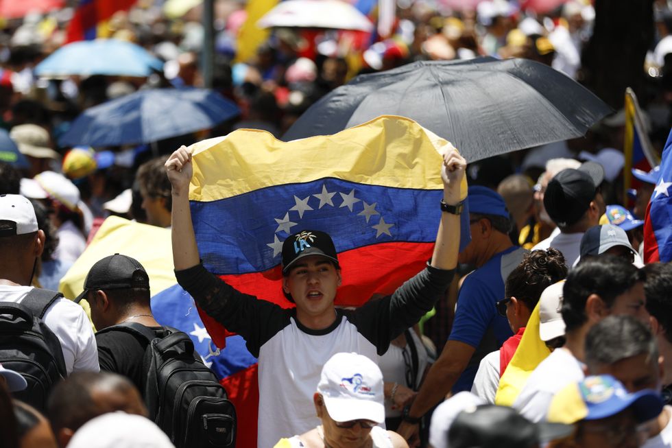 photo of young man holding venezuelan flag
