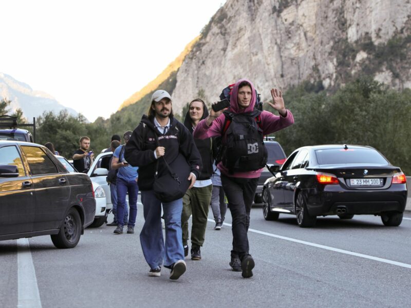 photo of young men walking on the road