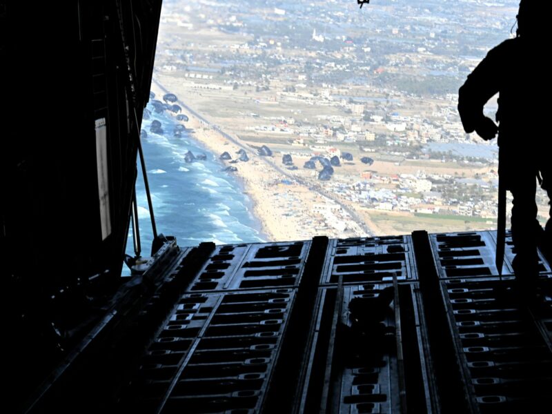 Photo shot from the back of a U.S. Air Force plane showing a soldier looking over aid being dropped over Gaza on March 2