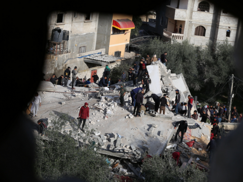 Photo taken from inside a destroyed building in Rafah, Gaza, showing people gathering amid the rubble left by an Israeli airstrike