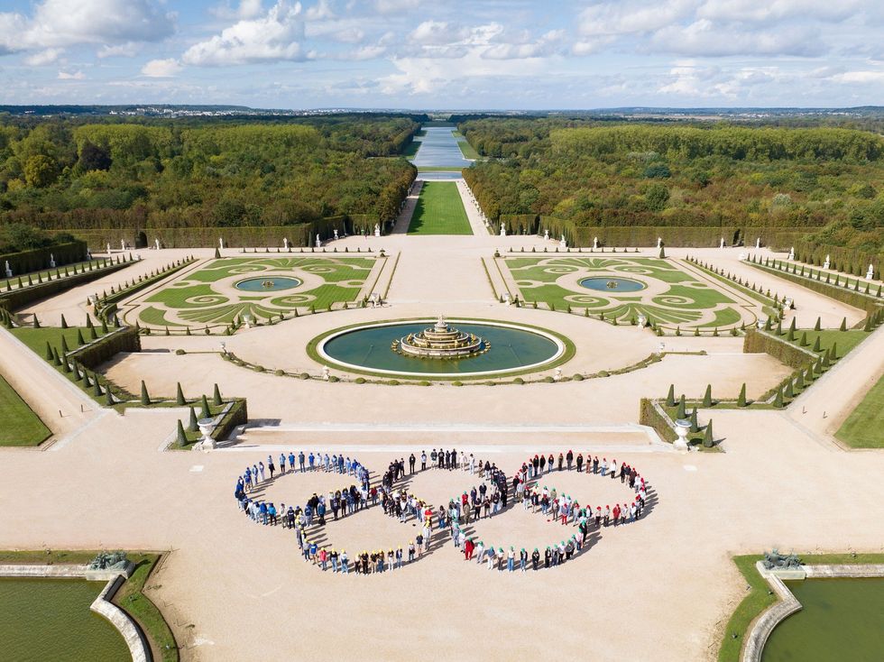Photograph at the gardens of Versailles where ​200 visiting students form the Olympic Rings a year before the start of the games in France.