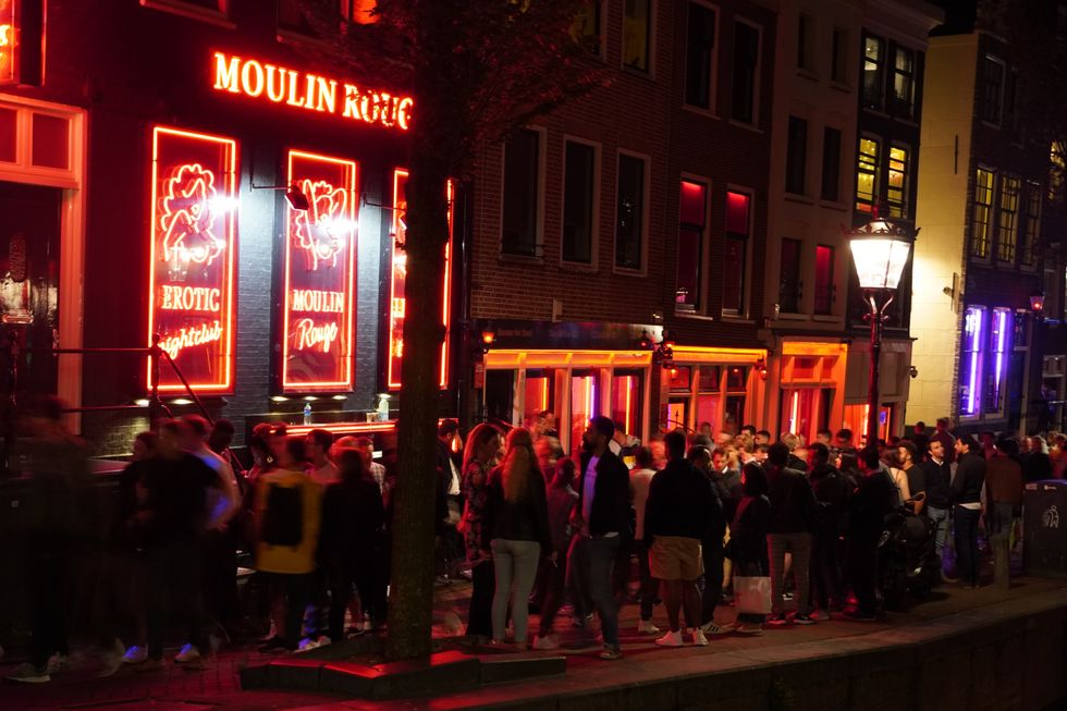 Photograph of a crowd in masterdom's red light district by night