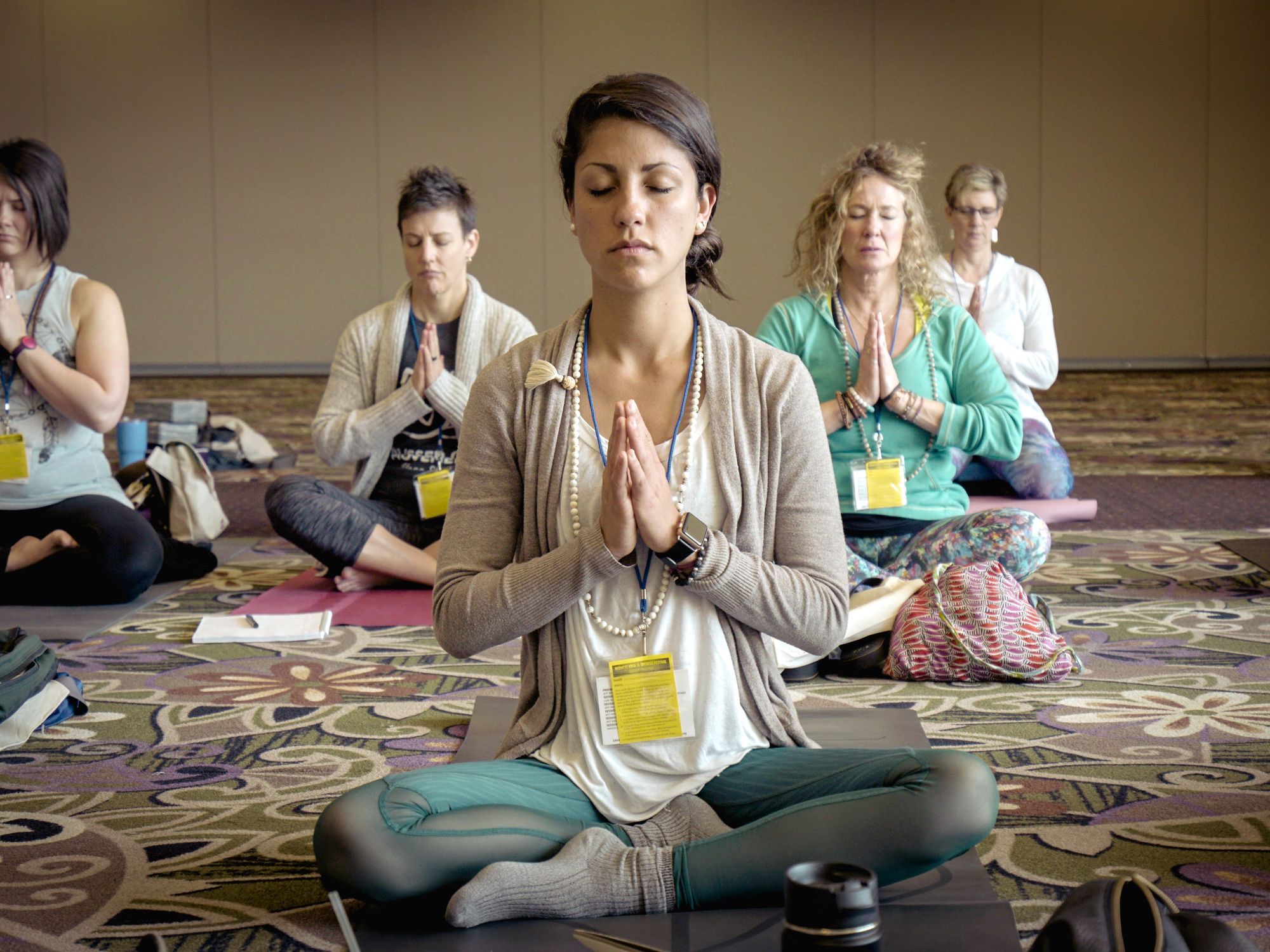 Photograph of a group of people doing yoga, sitting cross-legged