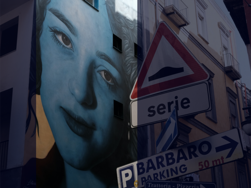Photograph of a large mural of a woman painted in blue on a wall in Naples