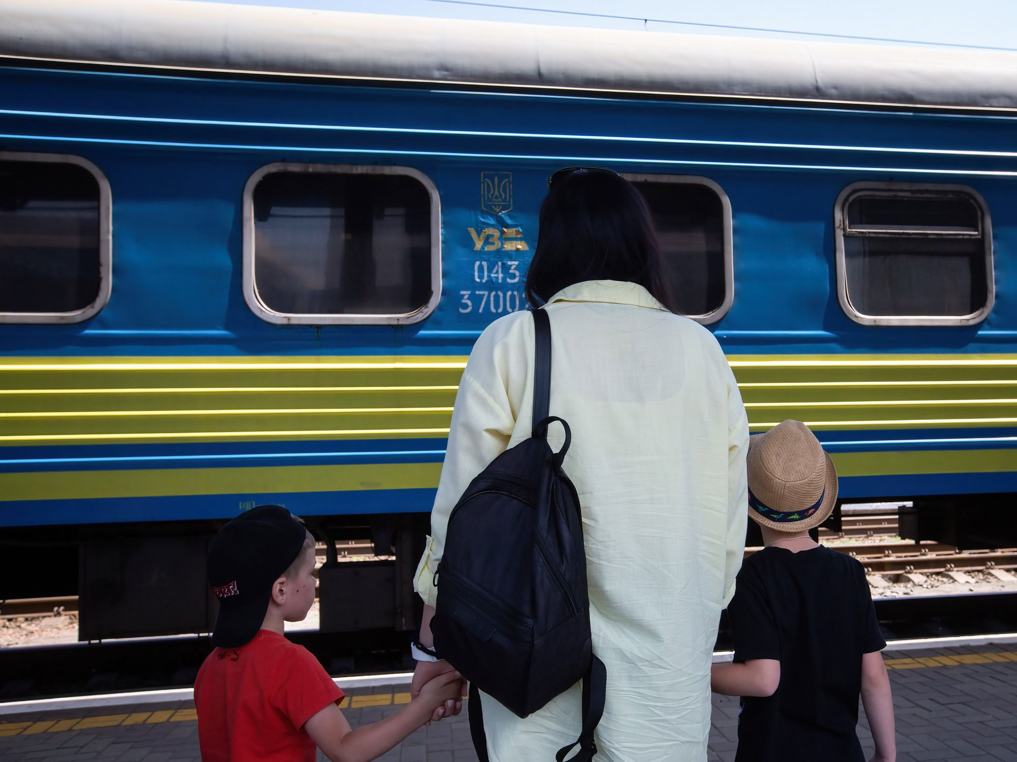 Photograph of a mother and her two children meeting an evacuation train from the Sumy region at the central railway station.​