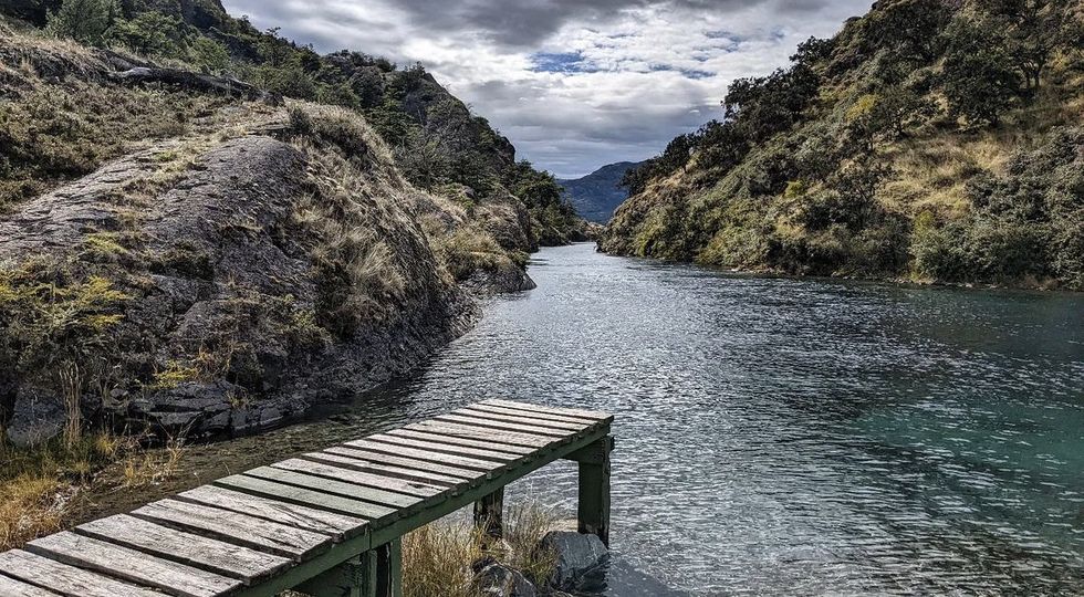 Photograph of a small pier leading into a blue toned river in the Patagonia National Park