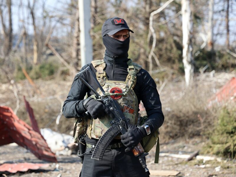 Photograph of a Wagner soldier in the city of Artyomovsk, holding a rifle.