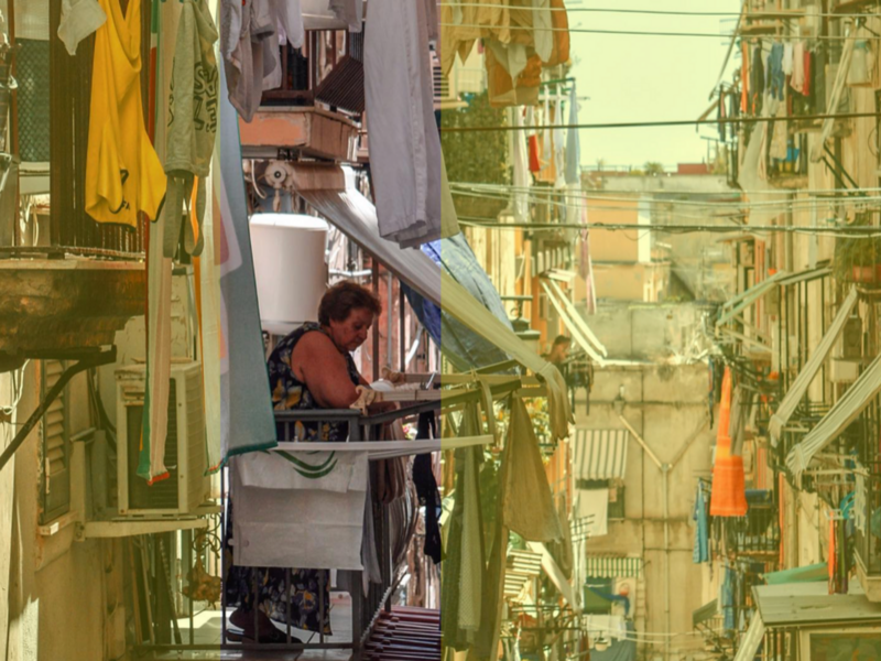 Photograph of a woman looking down onto the street from her balcony in Naples
