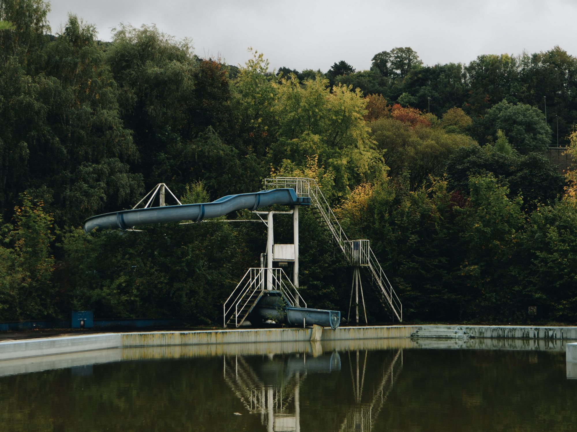 Photograph of an abandoned life leading into a swimming pool.