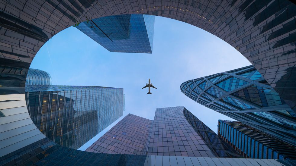 Photograph of an ​Airplane flying over La Défense
