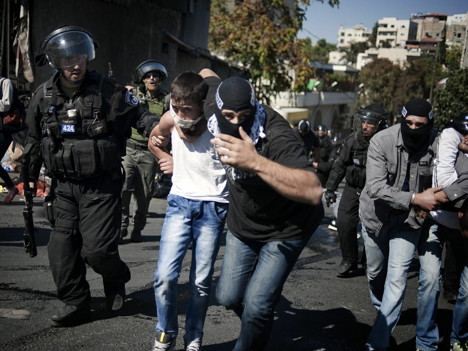 Photograph of an undercover Israeli police man arresting a young Palestinian boy.