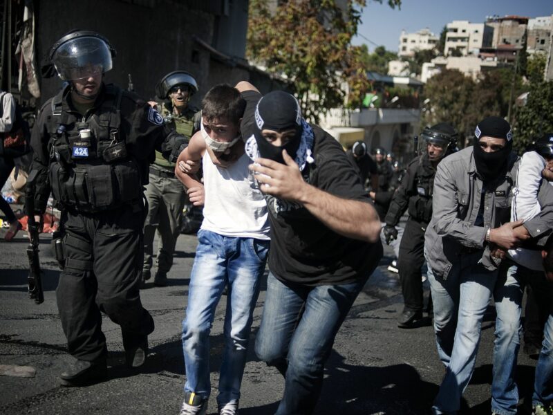 Photograph of an undercover Israeli police man arresting a young Palestinian boy.