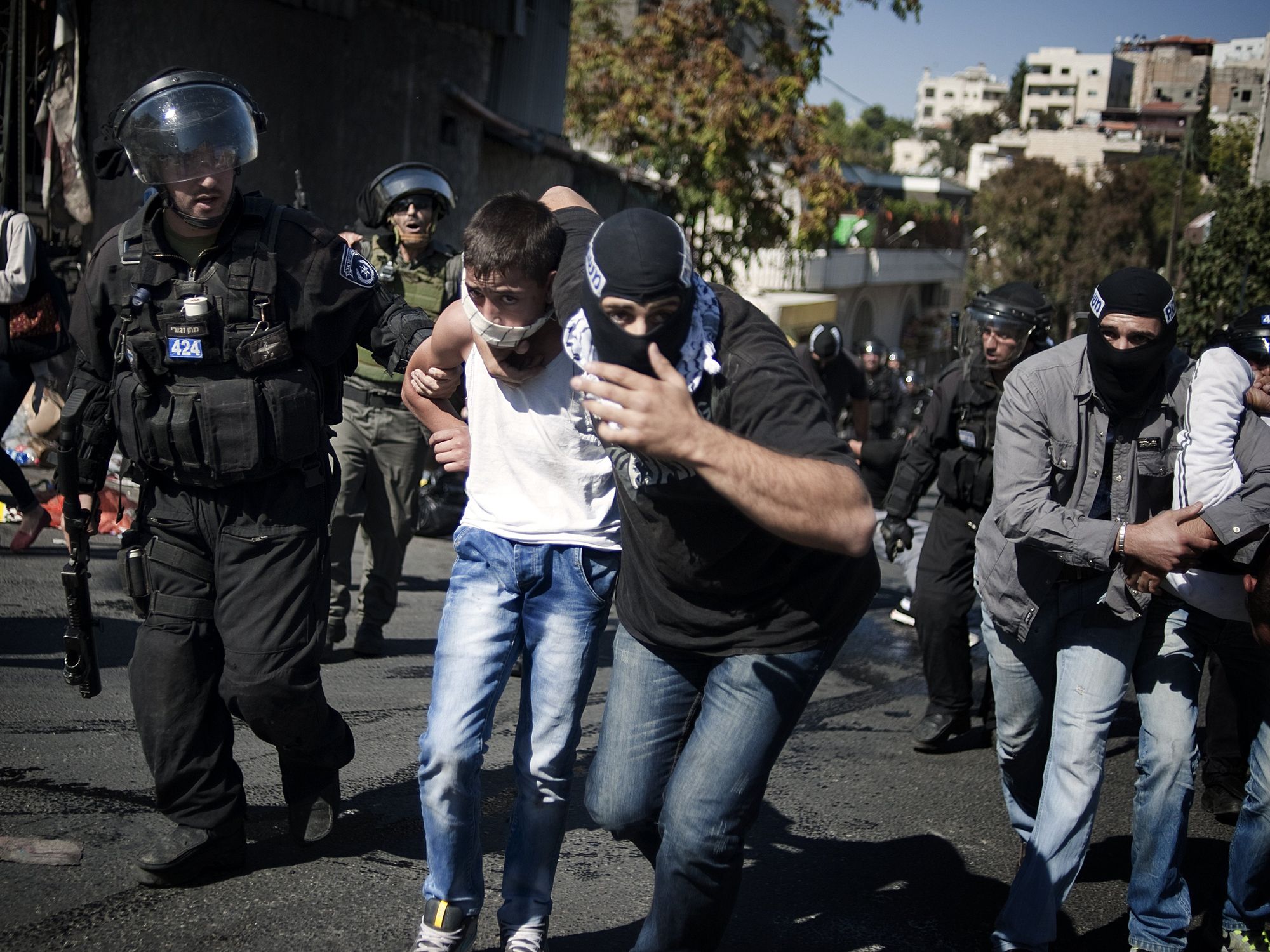 Photograph of an undercover Israeli police man arresting a young Palestinian boy.