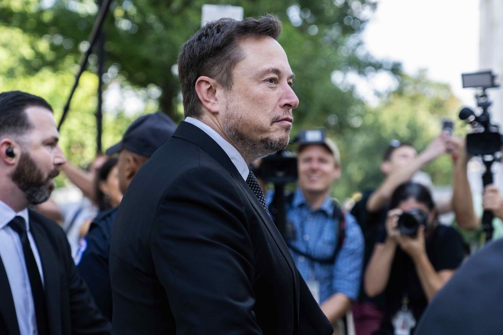 Photograph of Elon Musk walking through journalists