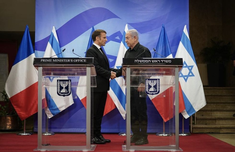 Photograph of French President Emmanuel Macron in a meeting with Israeli Prime Minister Benjamín Netanyahu, shaking hands.