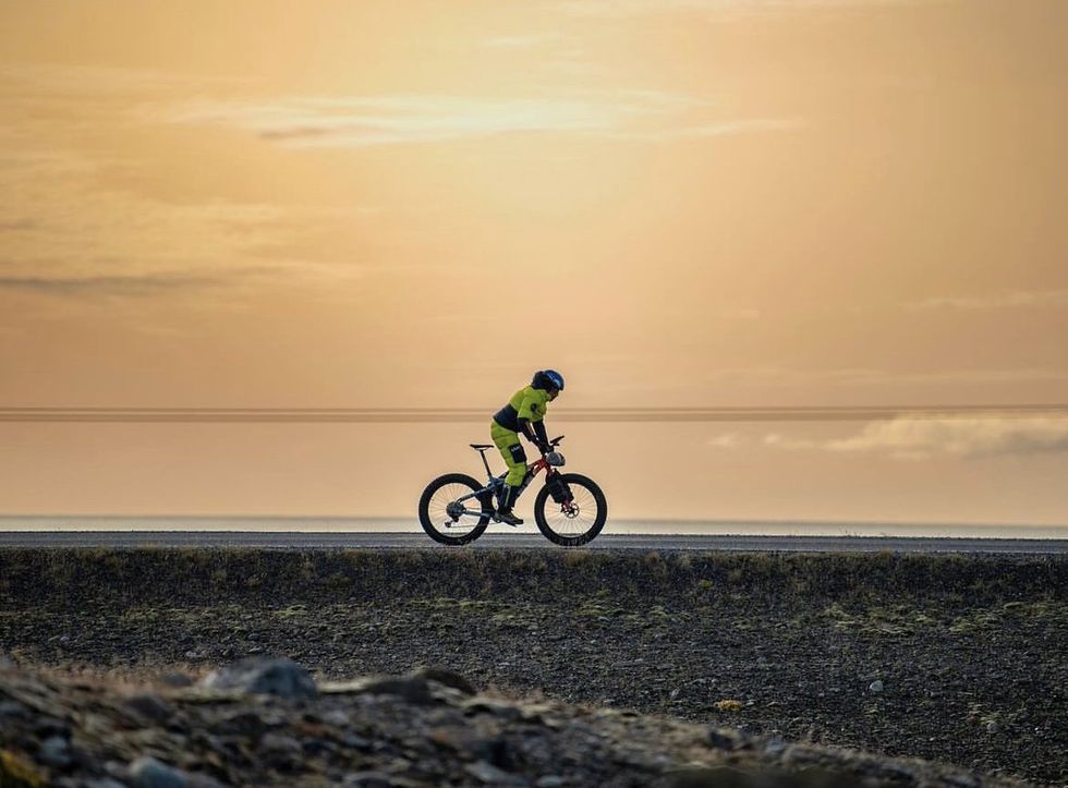 Photograph of Omar Di Felice cycling in the sunrise as he practices for his trip to Antarctica.