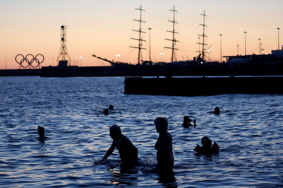 Photograph of people's silhouettes as they bathe in the Black Sea.