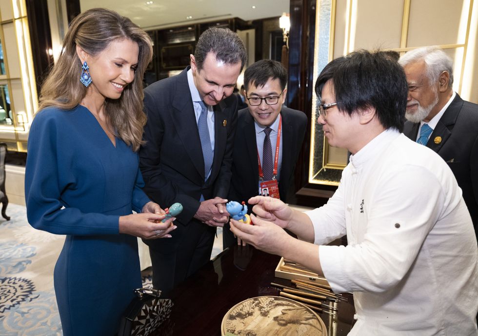 Photograph of Syrian President Bashar al-Assad and his wife Asma al-Assad being presented with Chinese heritage items.