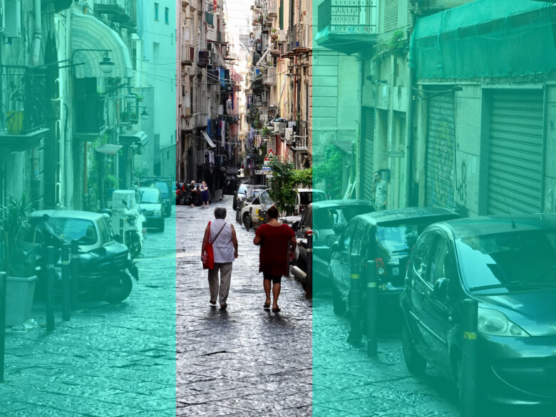 Photograph of the back of two women who walk down the old town streets of Naples