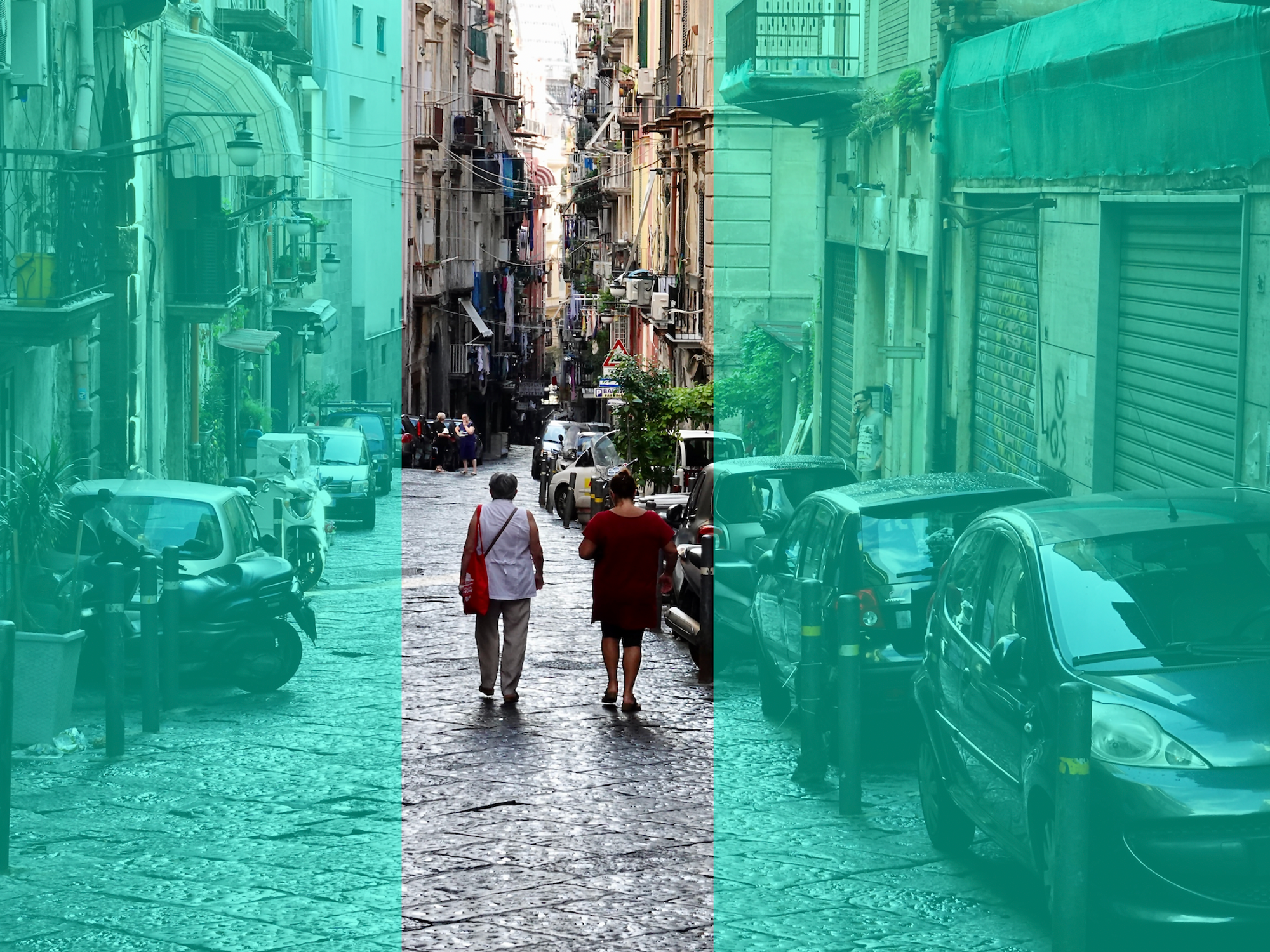 Photograph of the back of two women who walk down the old town streets of Naples