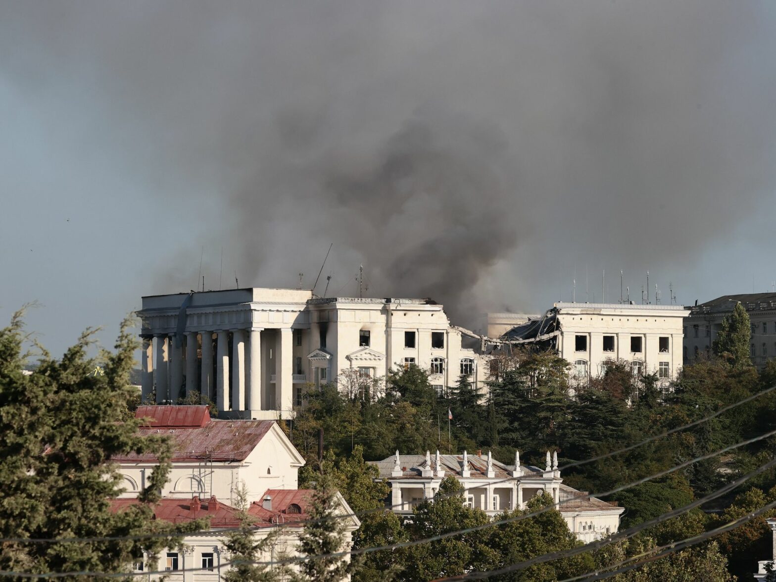 Photograph of the Russian Black Sea Fleet headquarters with smoke rising above it after a Ukrainian missile strike.