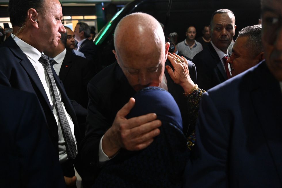 Photograph of the Tunisian President Kais Saied kissing a woman's forehead at the Municipal Market in Ariana.