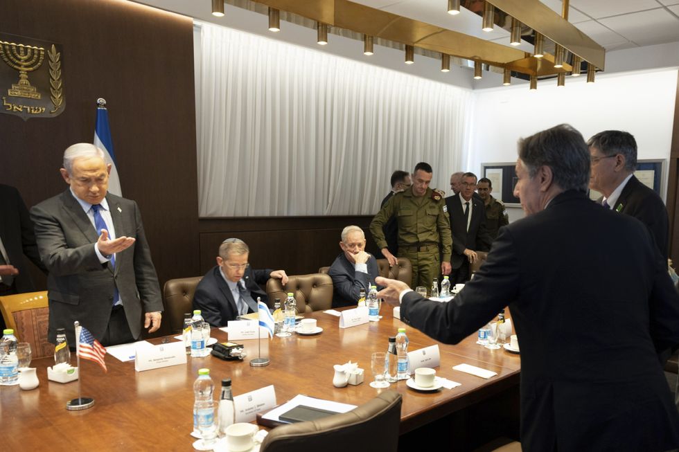 Photograph of U.S Secretary of State Antony Blinken and Israeli Prime Minister Benjamin Netanyahu both invite each other to sit before the start of a meeting with officials in Tel Aviv..