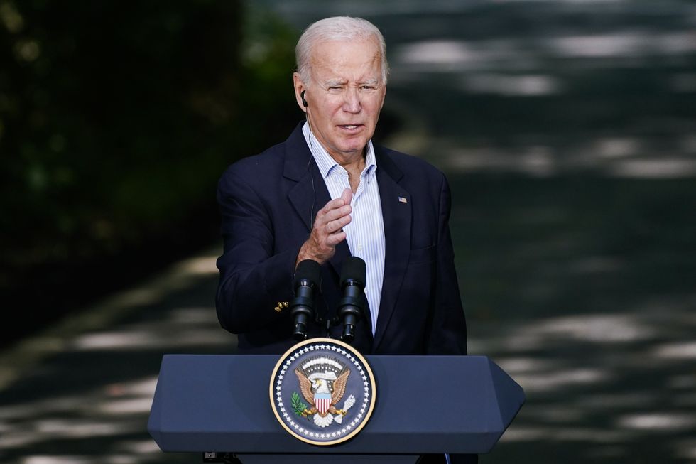 Photograph of United States President Joe Biden speaking at a podium during Trilateral Summit held at Camp David.