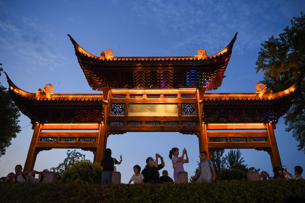 Photograph taken at dusk of the Fuzi (Confucius) Temple in Nanjing with several tourists taking otitis on their cellphones,