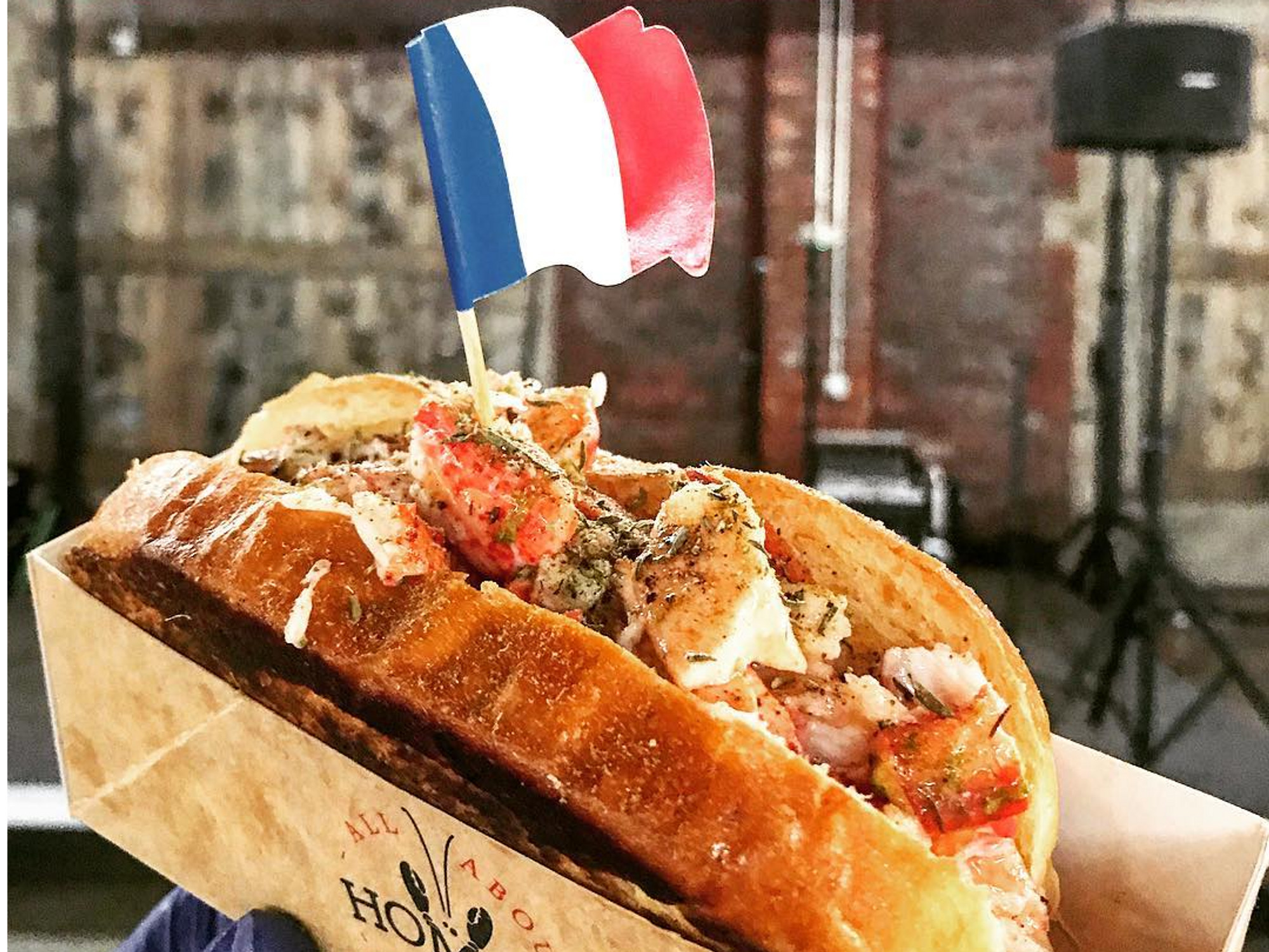 Picture of a crab sandwich with the French flag sticking out of it.