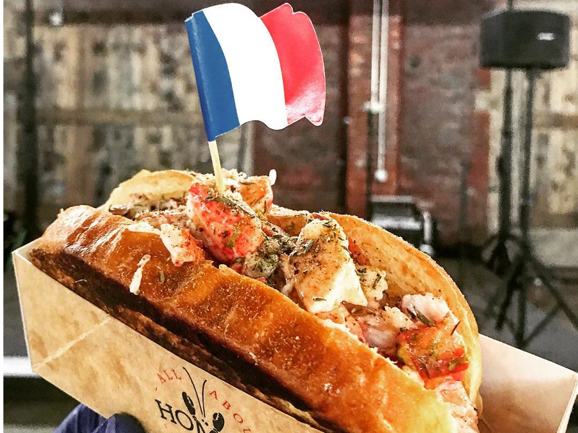 Picture of a crab sandwich with the French flag sticking out of it.