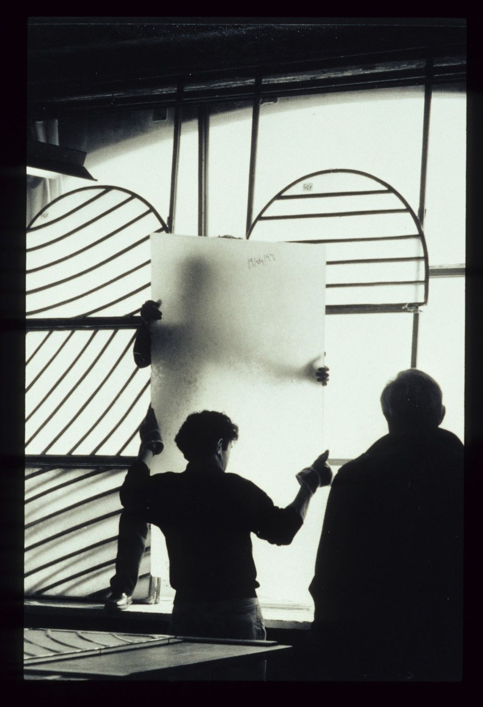 Pierre Soulages (right) overseeing workers handling stained glass at the Abbey Church of Sainte-Foy.