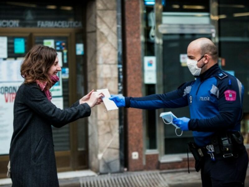 Police in Madrid hand out face masks in the metro on Monday