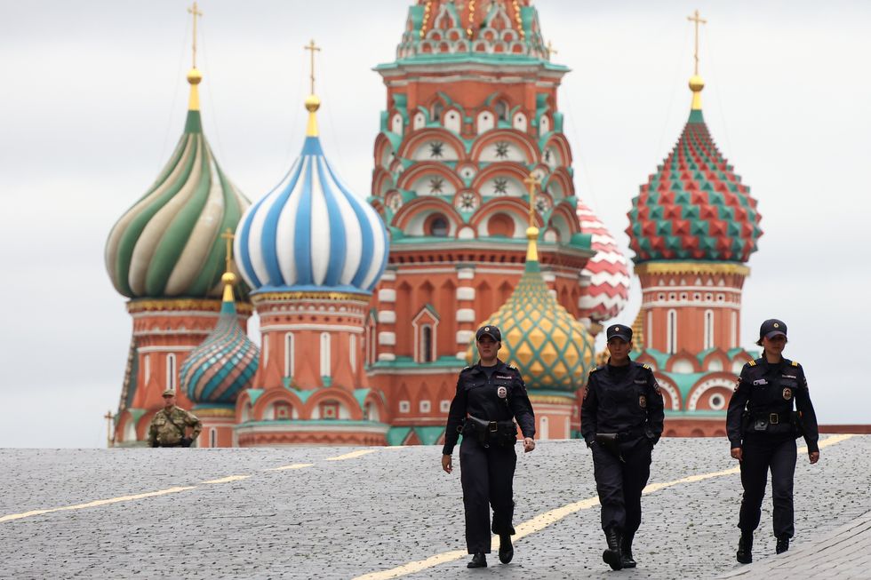 Police patrol Red Square with Saint Basil's cathedral in the background.