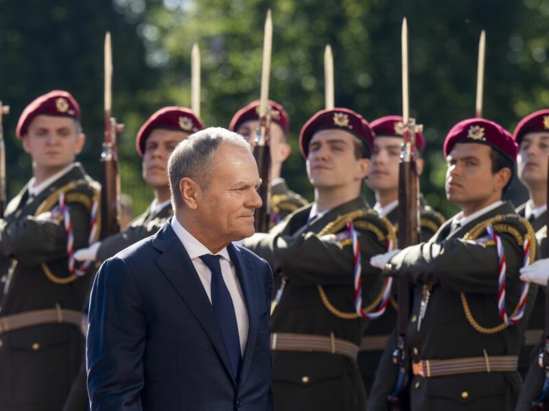 Polish Prime Minister Donald Tusk walks past members of the Czech military