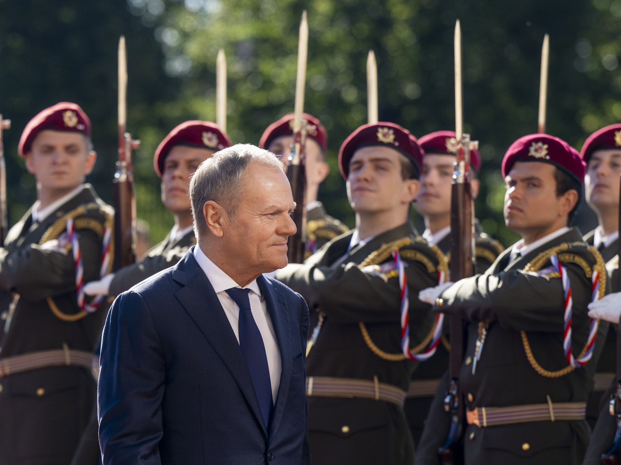Polish Prime Minister Donald Tusk walks past members of the Czech military