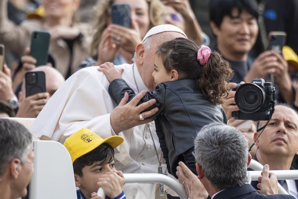Pope Francis hugs a little girl during his traditional Wednesday General Audience.