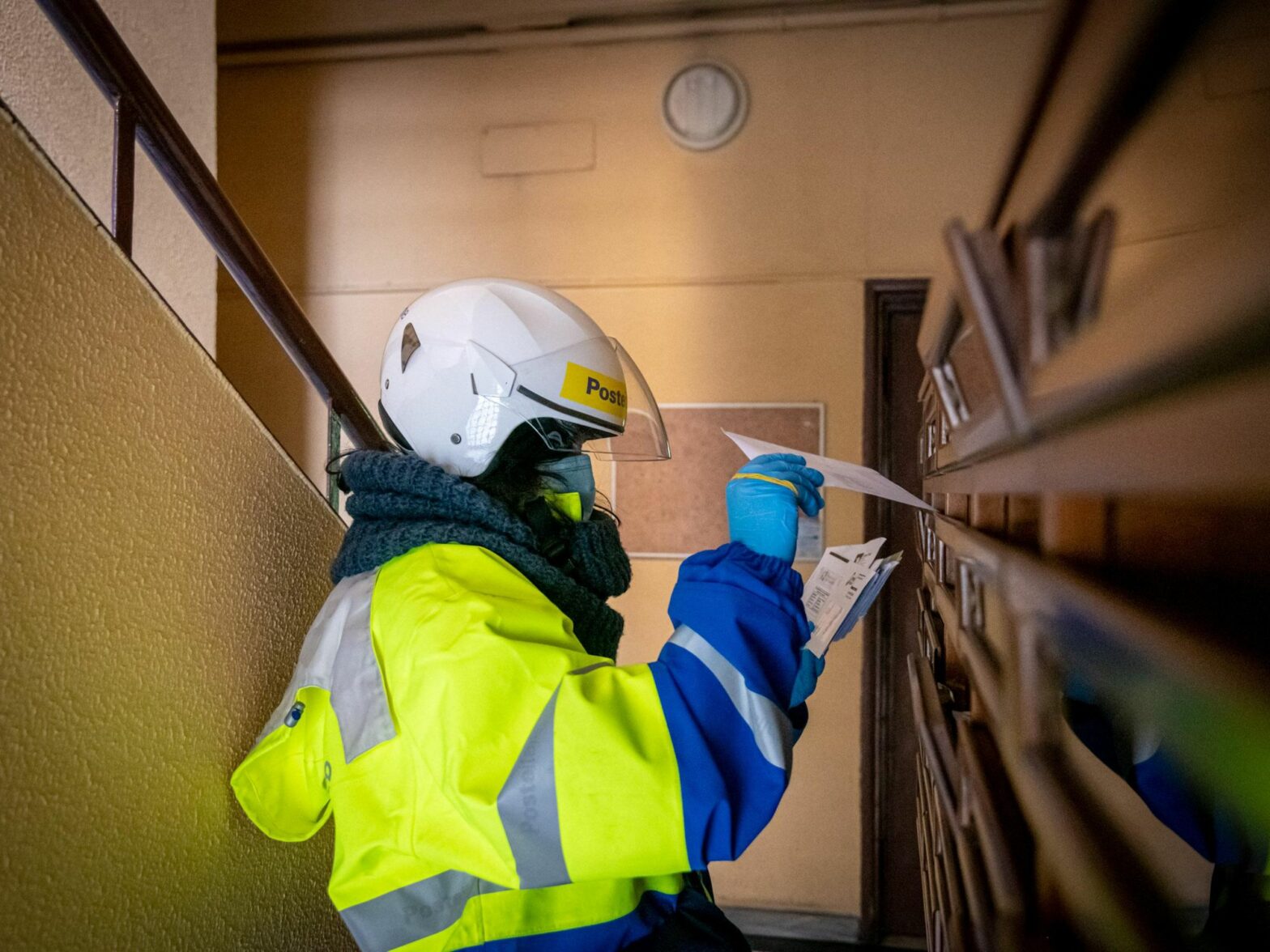 Postal worker in Italy delivers mail to apartment mailboxes